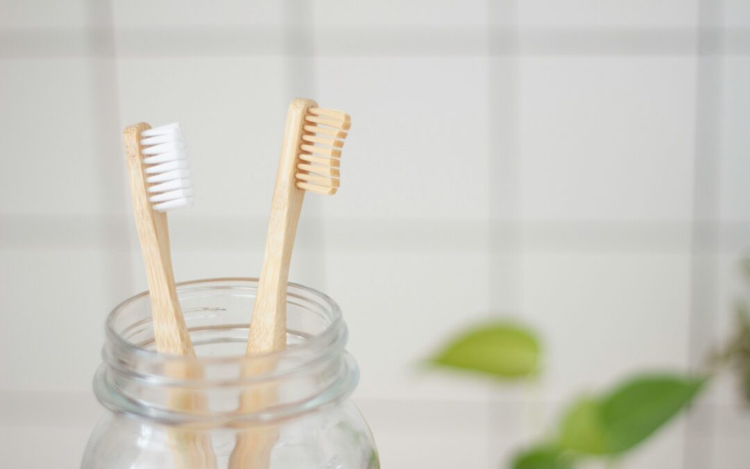 Bamboo toothbrush in a glass jar representing natural gingivitis remedies and gum care