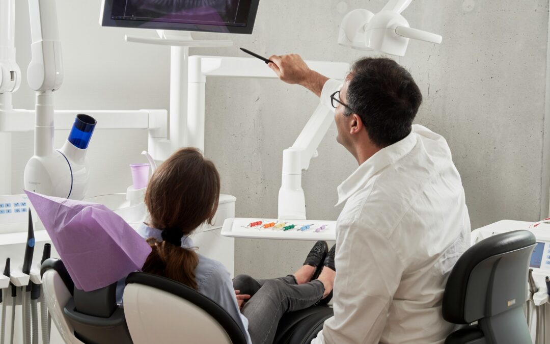 Dentist reviewing a dental X-ray to find out why a toothache returns after root canal treatment